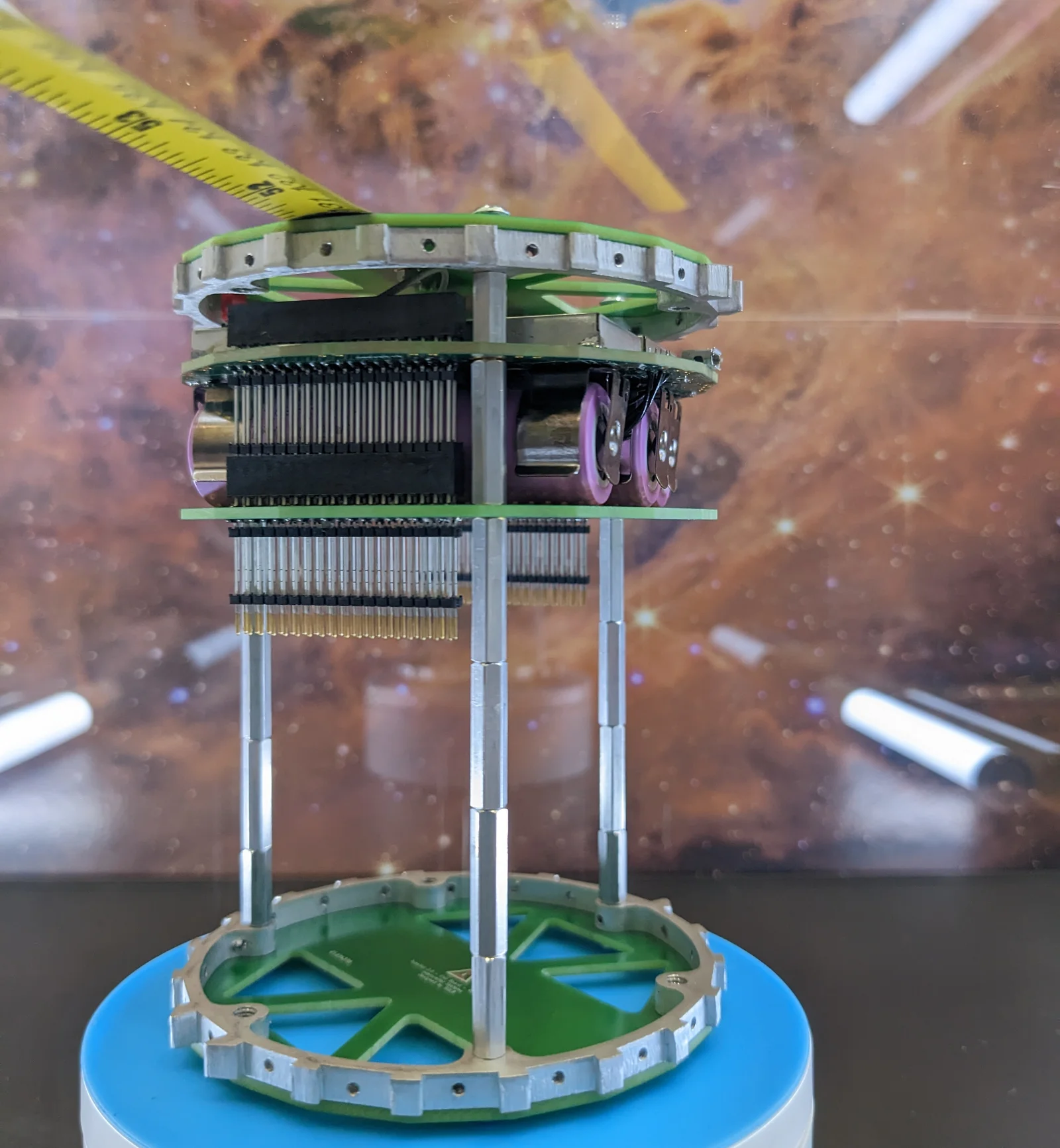 The cylindrical BobcatOrbiter TubeSat partially assembled, showing internal stack of circuit boards through the chassis.