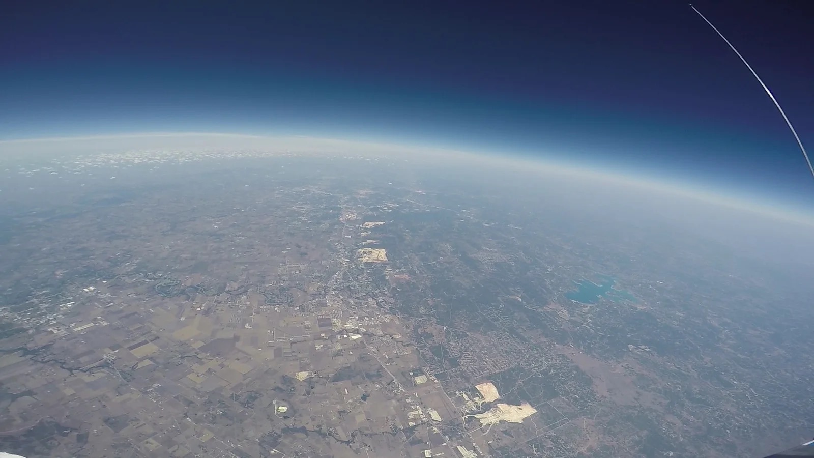 View from the Icarus I balloon at 80,000 feet, showing the curve of the Earth and the black of near-space above San Marcos, Texas.