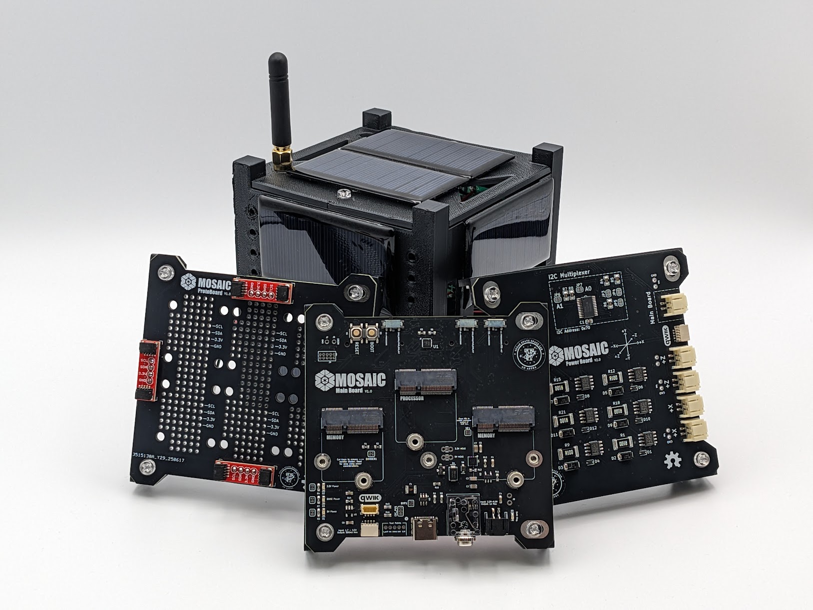 MOSAIC modular CubeSat training boards laid out in a grid — multiple subsystem PCBs including power, communications, and onboard computer modules, used as the lab's hands-on teaching hardware.