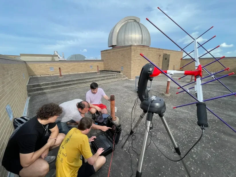 Space Lab members and Dr. Rangelov testing NomadLink, a portable satellite radio system, outdoors with antenna and laptop.
