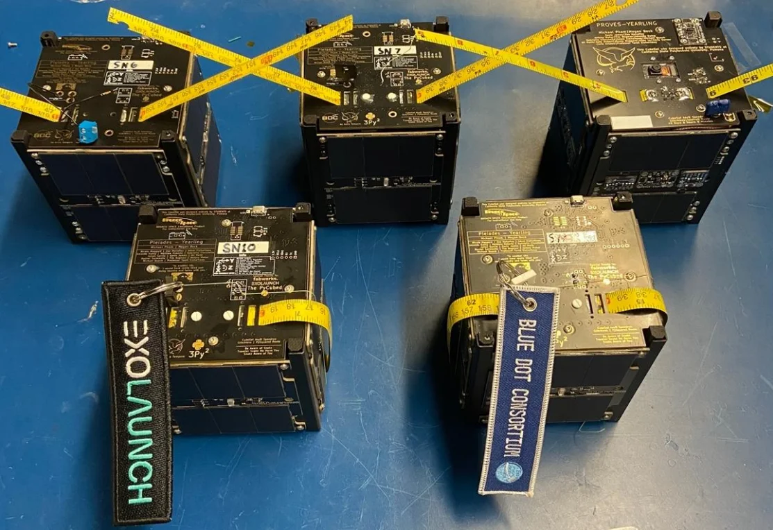Five PROVES Kit CubeSats from Cal Poly Pomona's Pleiades Yearling fleet, lined up on a white surface for inspection.